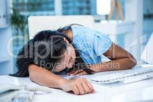 Tired businesswoman sleeping at her desk