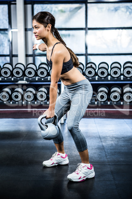 Serious fit woman lifting kettlebell