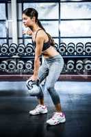 Serious fit woman lifting kettlebell