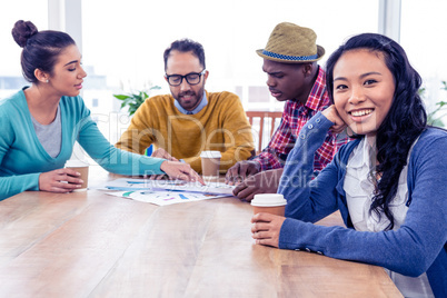 Portrait of happy business woman with colleagues in background