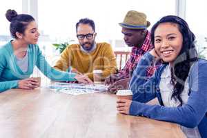 Portrait of happy business woman with colleagues in background