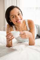 Smiling brunette holding cup