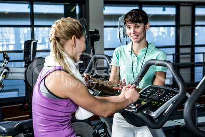 Fit woman doing exercise bike with trainer