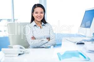 Smiling businesswoman with arms crossed looking at camera