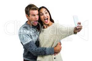 Couple making face while taking selfie on mobile phone