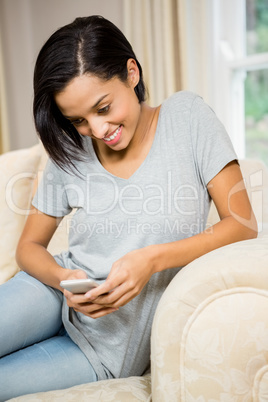 Smiling brunette using smartphone