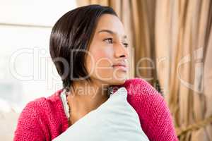 Day dreaming brunette holding pillow