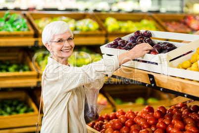 Senior woman holding bag with apple