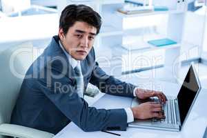 Tired businessman using his computer