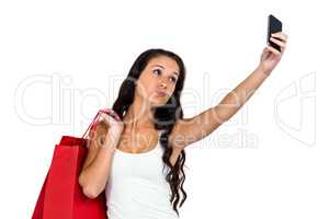 Pretty woman holding shopping bags taking selfie