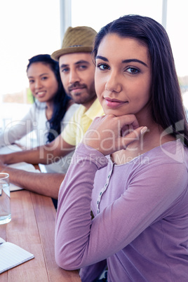 Portrait of beautiful businesswoman sitting with colleagues