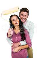 Portrait of smiling couple holding paint roller