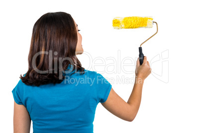 Rear view of woman holding paint roller