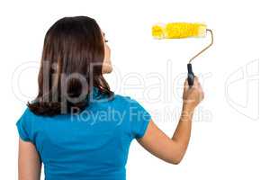 Rear view of woman holding paint roller