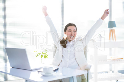 Businesswoman rejoicing with arms outstretched