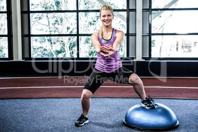 Fit woman doing exercise with bosu ball