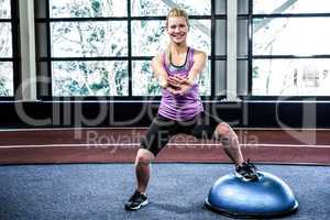 Fit woman doing exercise with bosu ball