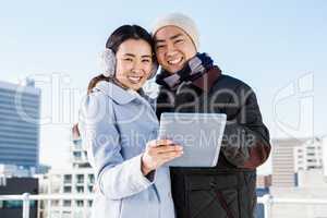 Portrait of happy couple using digital tablet