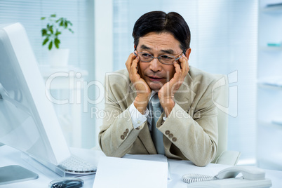 Tired businessman holding his head