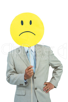 Businessman holding angry smiley face balloon