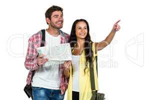 Happy couple holding map and pointing somewhere