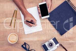 Overhead view of businessman writing on notepad