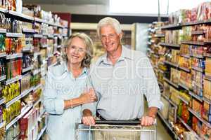 Smiling senior couple with cart