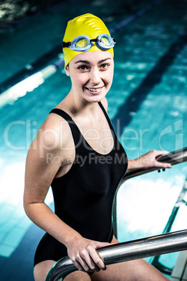 Smiling swimmer woman getting out of the swimming pool