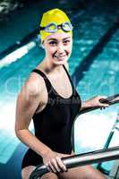 Smiling swimmer woman getting out of the swimming pool