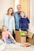 Portrait of happy family opening boxes
