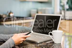 Close up of woman using smartphone and laptop