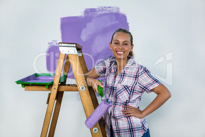Smiling woman painting a wall