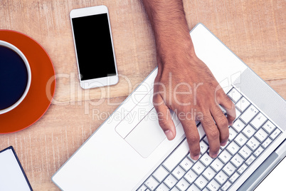 Overhead view of businessman working on laptop
