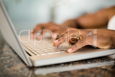 Masculine hands typing on laptop keyboard