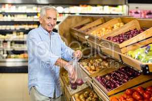 Smiling senior man buying red onions
