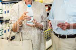 Senior couple buying milk and checking list