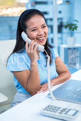 Smiling businesswoman using landline