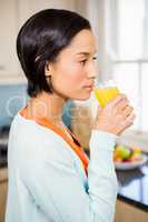 Smiling brunette up to drink orange juice