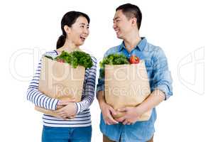 Couple looking at each other while holding grocery bags