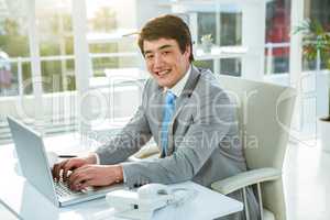 Smiling asian businessman using his computer