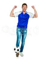 Smart man holding football with arms raised