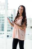 Smiling woman using tablet looking at camera