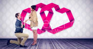 Composite image of handsome man proposing woman while kneeling