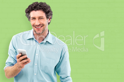 Composite image of businessman holding mobile phone over white b