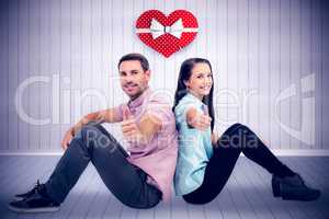 Composite image of  smiling couple sitting showing thumbs up