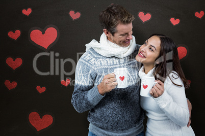 Composite image of festive couple smiling and holding mugs