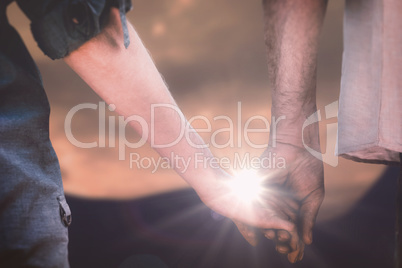 Composite image of couple holding hands in park