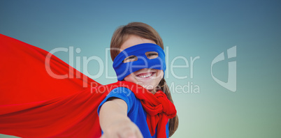 Composite image of smiling masked girl pretending to be superher