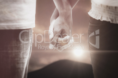 Composite image of young couple holding hands in the park