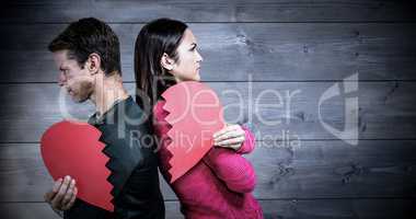 Composite image of serious couple standing back to back
